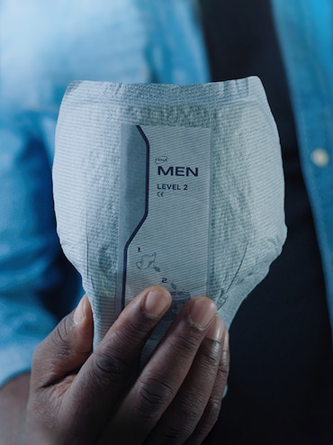 Protection TENA pour hommes tenue par une main d’homme 