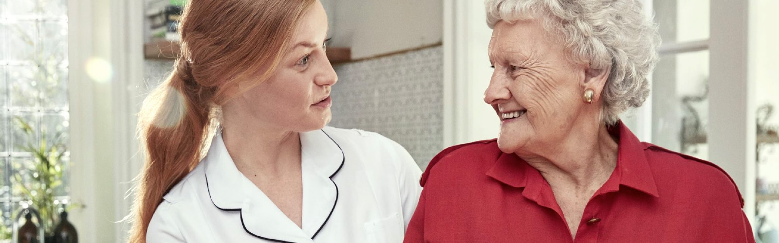 Nurse talking to a smiling elderly woman