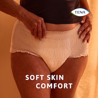 A utilizar o produto TENA Pants protect+ em ambiente noturno, destacando o conforto suave para a pele