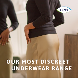 Una donna elegantemente vestita che indossa una mutandina TENA Silhouette, la nostra più discreta gamma di biancheria intima