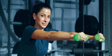Image of woman holding dumbbells in a gym