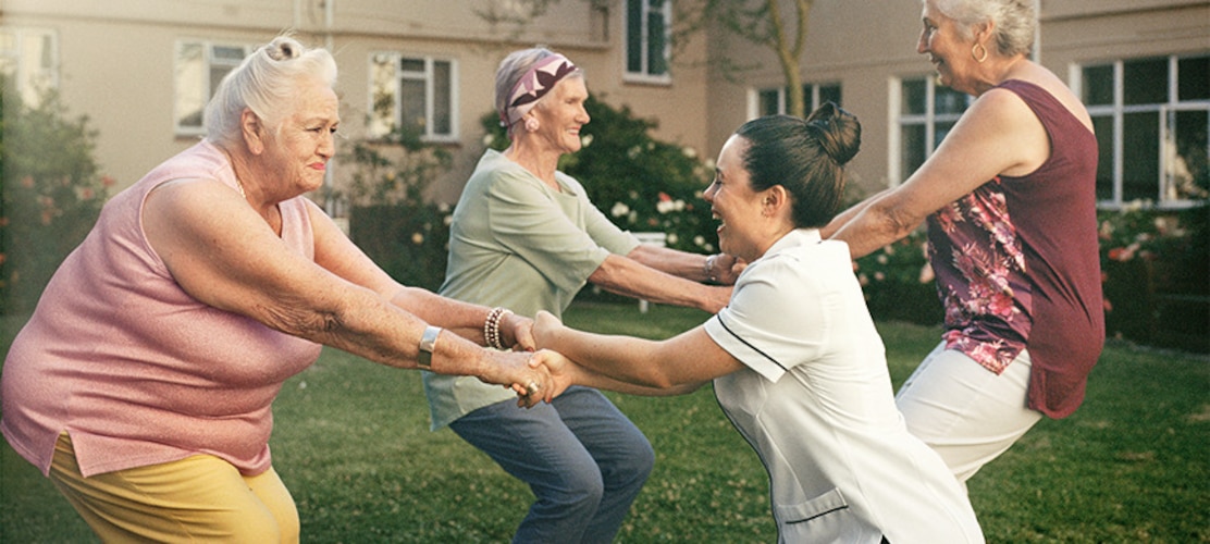Ältere Frauen tanzen auf einer Wiese