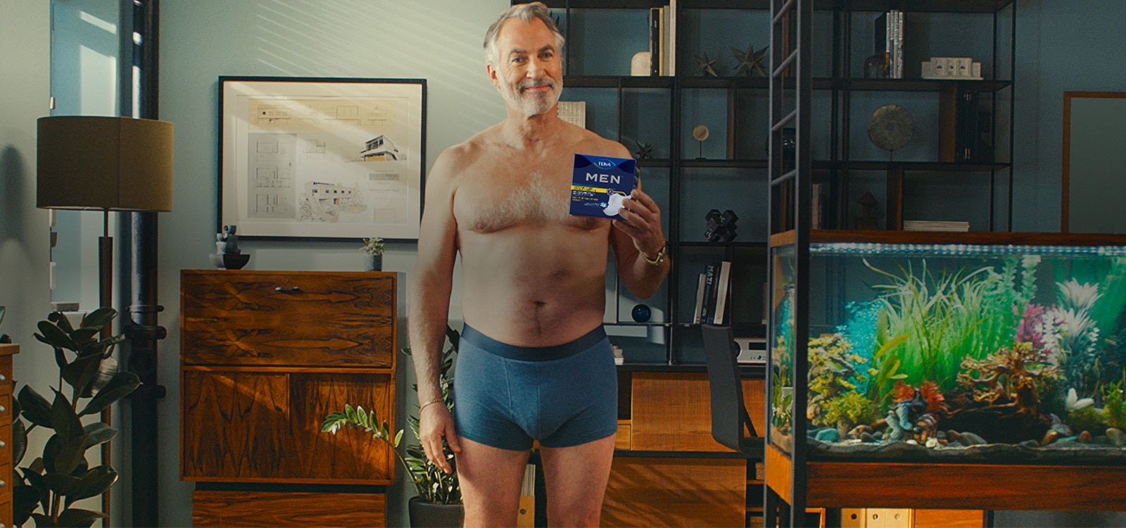 A confident, relaxed 50+ man poses in TENA underwear. 