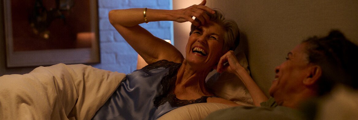 Twee vrouwen lachend in bed