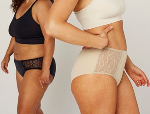 Two women standing next to each other, wearing TENA Silhouette Washable underwear in black and beige.