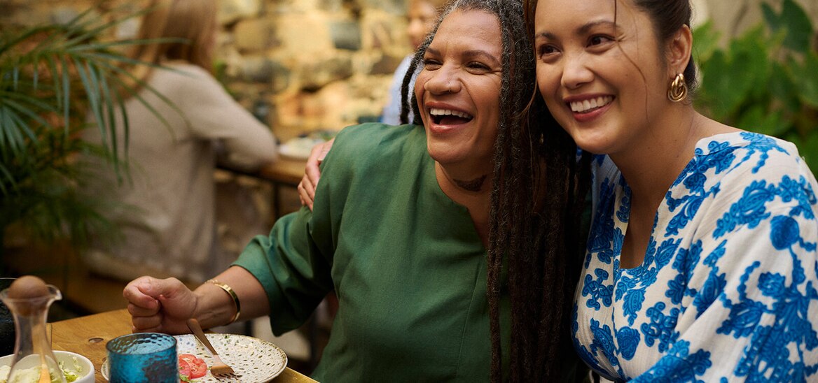 Two friends laugh during lunch