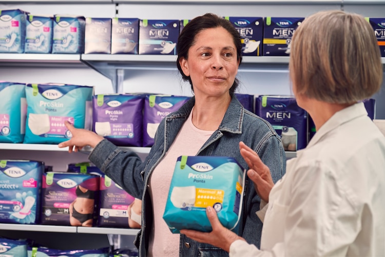 Customers holding TENA products in a pharmacy