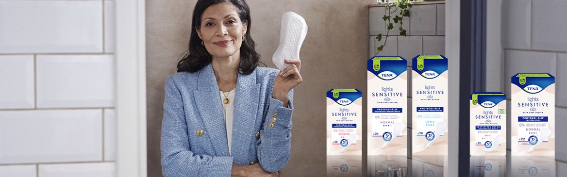 Woman holding up TENA Lights Sensitive pads
