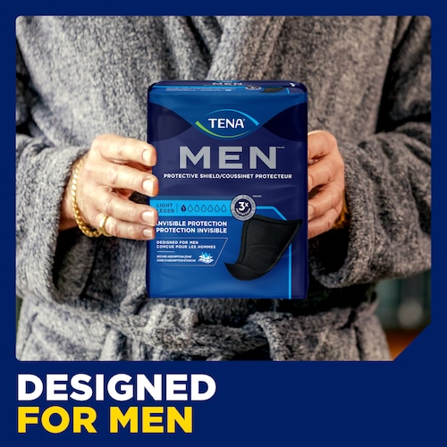 Person holding up the pack of TENA Men Protective Shield Light with the caption "designed for men"