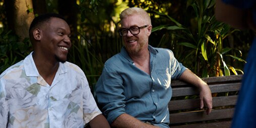 Friends sit on a bench and laugh