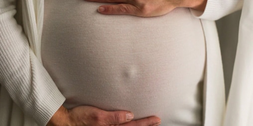 Kobieta w ciąży trzymająca się za brzuszek