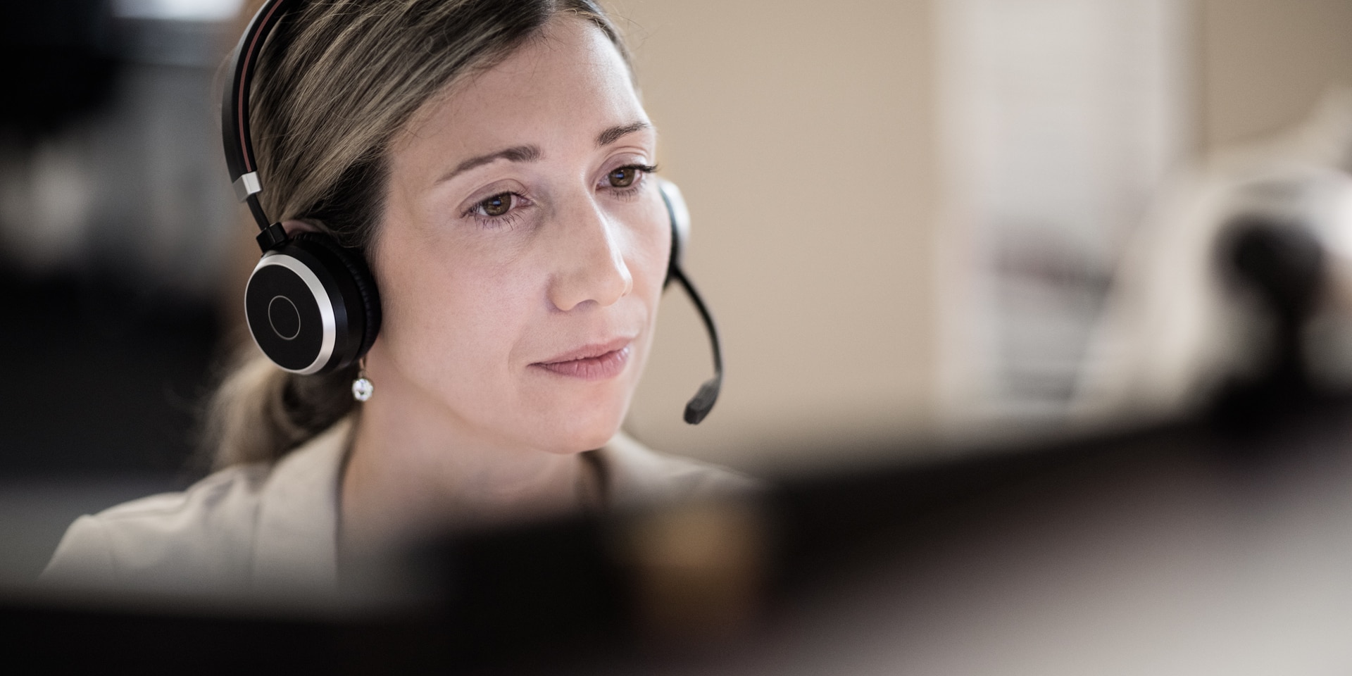 Eine Frau mit einem Headset vor einem Computer