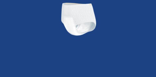 Starsza kobieta o srebrnych włosach, ubrana w jasnoniebieską koszulę w paski, spaceruje po piaszczystej plaży z młodszym mężczyzną niosącym deskę surfingową. Fale oceanu rozbijają się o skalistą linię brzegową w tle, a słońce rzuca ciepły blask na scenę.