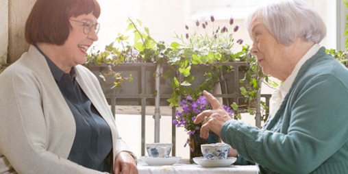 Two women talk while drinking tea