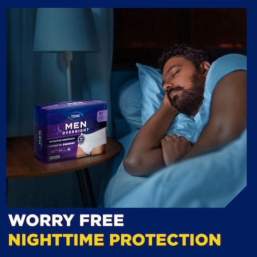 Product TENA Men Overnight Max underwear lying on night table next to a sleeping man