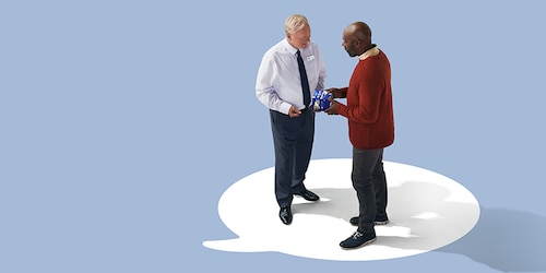 Two men holding and discussing a TENA product